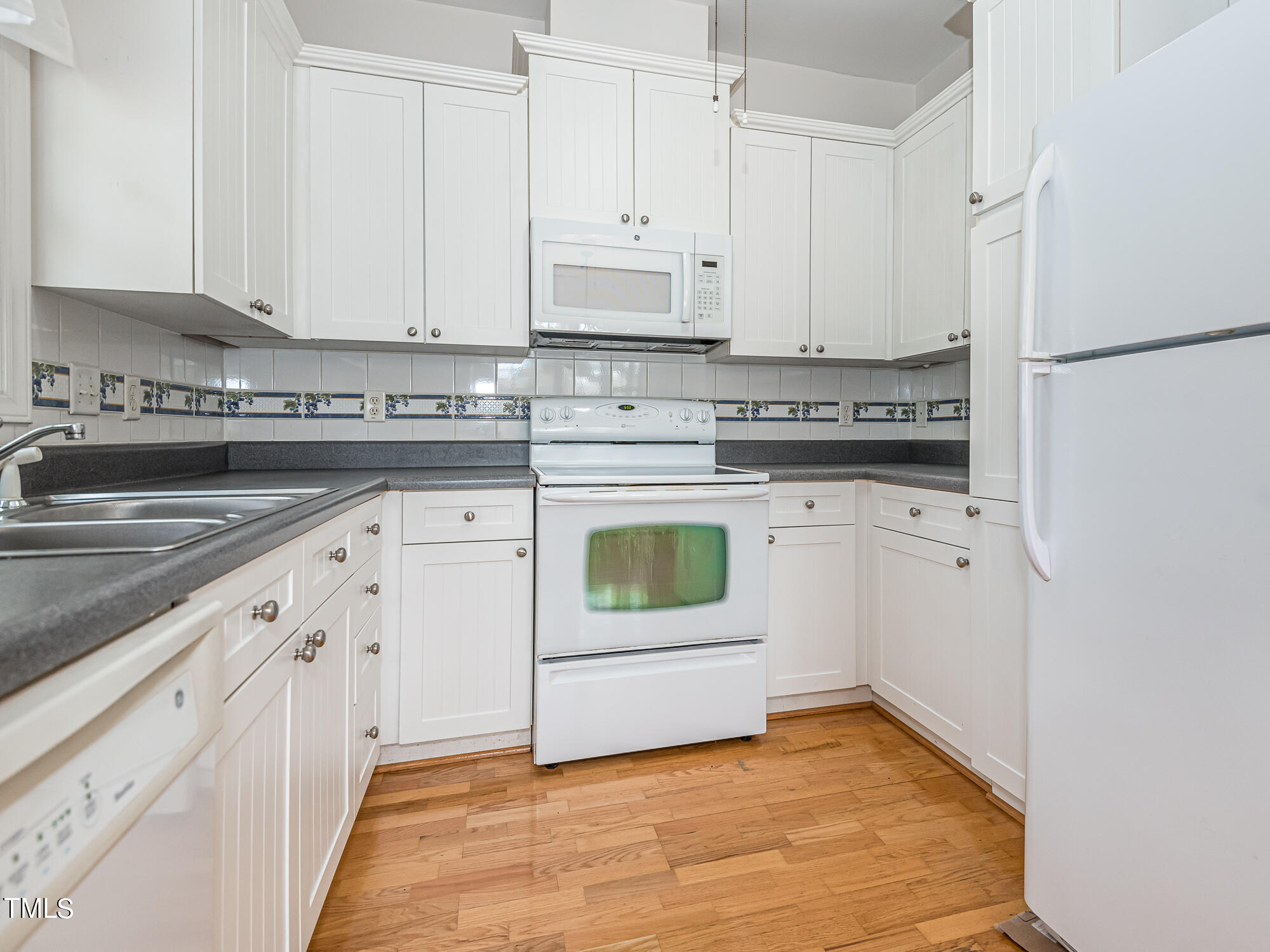 8041 Allyns Landing Way, Unit 103 Raleigh, NC 27615 - Photo 21 of 33 a kitchen with white cabinets and white appliances