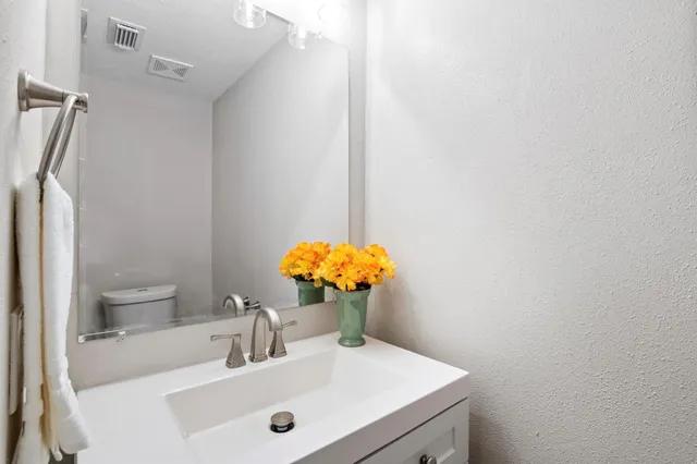 a bathroom with a sink a toilet and a mirror