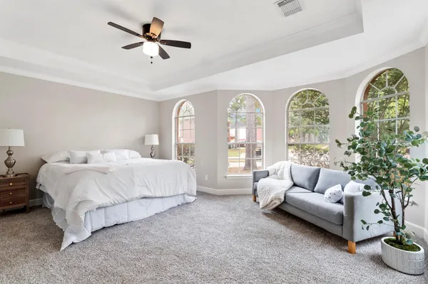 a spacious bedroom with a bed and a couch