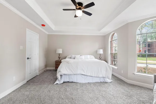 a bedroom with a bed and a large window