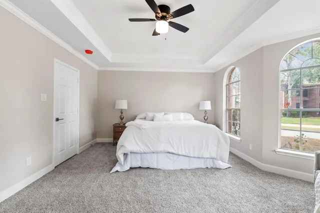 a bedroom with a bed and a large window