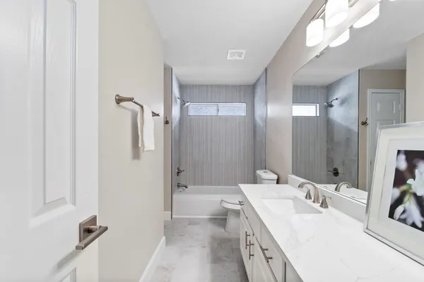 a spacious bathroom with a double vanity sink a mirror and a shower