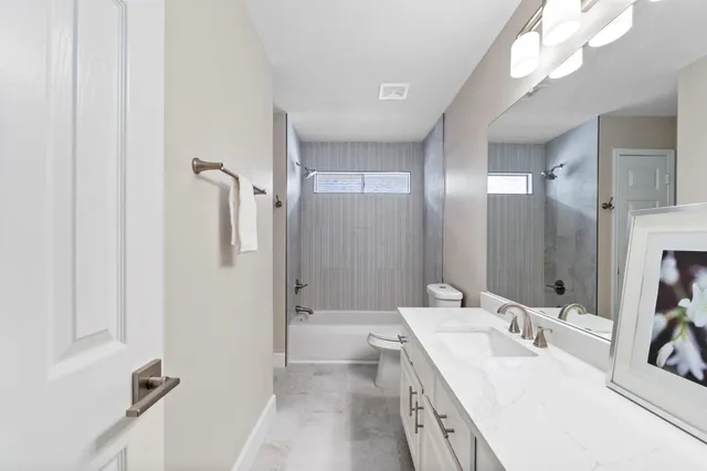 a spacious bathroom with a double vanity sink a mirror and a shower