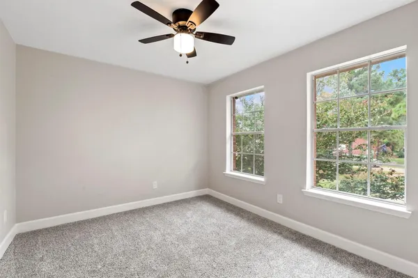 an empty room with a window and a fan