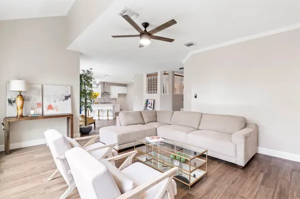 a living room with furniture a ceiling fan and a rug