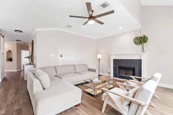 a living room with furniture a fireplace and a ceiling fan