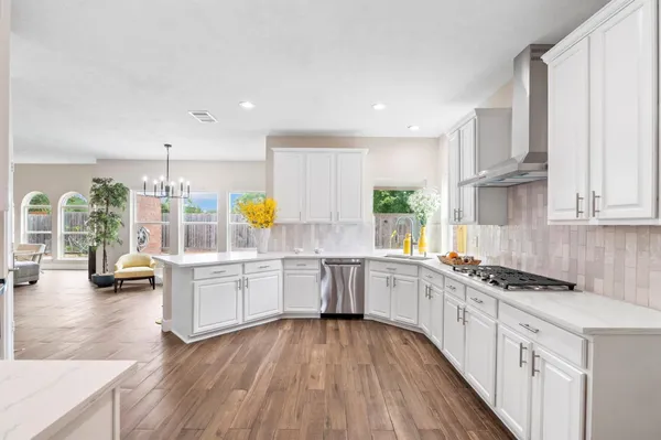 a kitchen with counter top space a sink wooden floor and stainless steel appliances