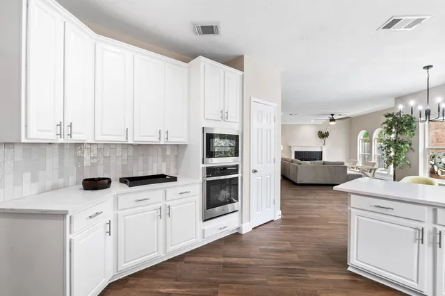 a kitchen with stainless steel appliances white cabinets and a fireplace