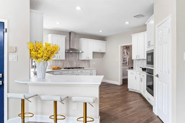 a kitchen with stainless steel appliances white cabinets and wooden floor