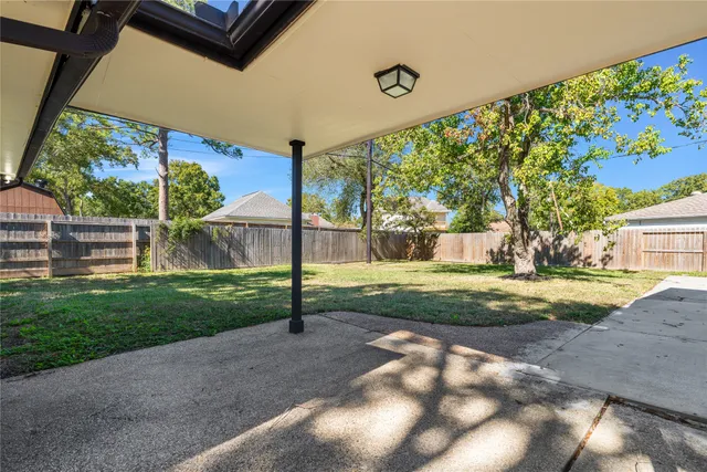 a view of empty room with wooden floor and windows