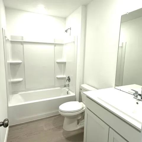 a bathroom with a bathtub shower sink vanity and a toilet