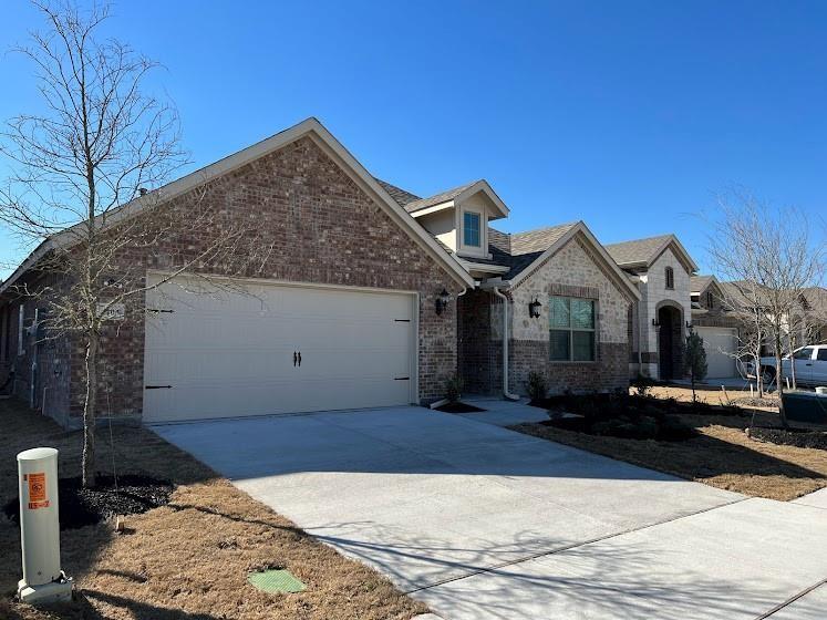 1408 Rendyn Street Anna, TX 75409 - Photo 2 of 23 Brick and stone exterior with dormer window accents, attached garage, and concrete driveway