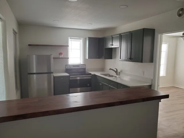 a kitchen with granite countertop a refrigerator and a sink