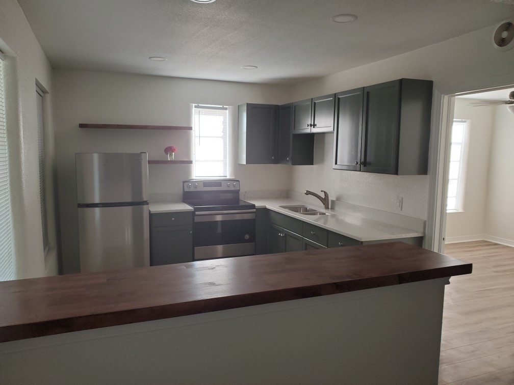 615 Pecan Street Junction, TX 76849 - Photo 11 of 14 a kitchen with granite countertop a refrigerator and a sink