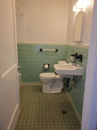 a bathroom with a sink toilet and a mirror