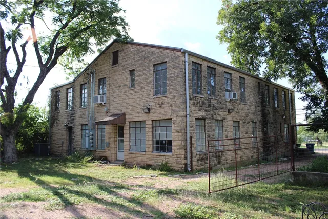 a brick house that has a tree in front of it
