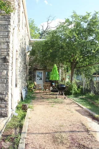 a view of house with backyard and sitting area