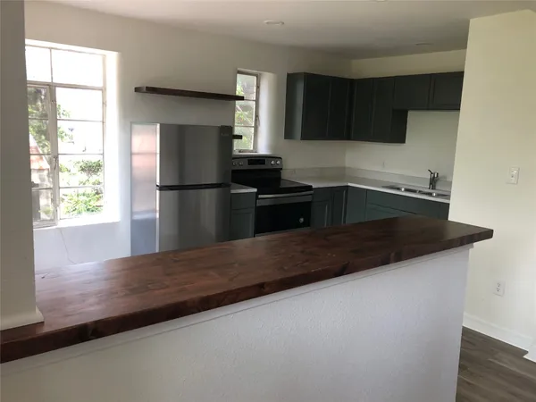 a kitchen with granite countertop a refrigerator sink and stove