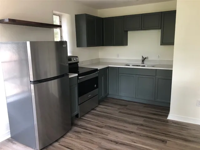 a kitchen with granite countertop a refrigerator and a sink