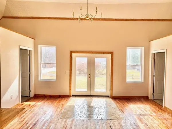 a view of a room with wooden floor and window