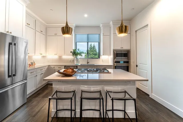 a kitchen with a table chairs refrigerator and microwave
