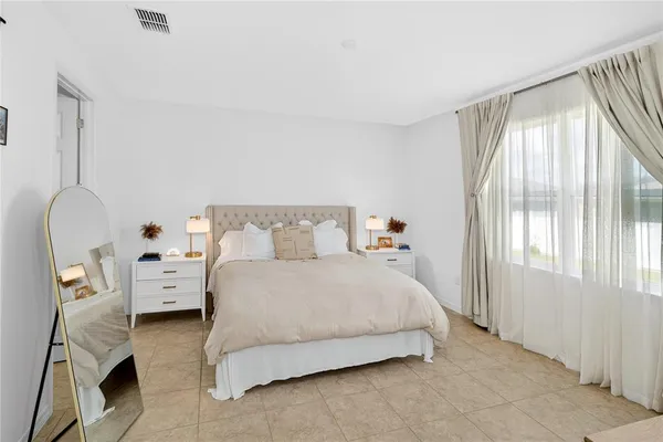 a bedroom with a bed and a large window