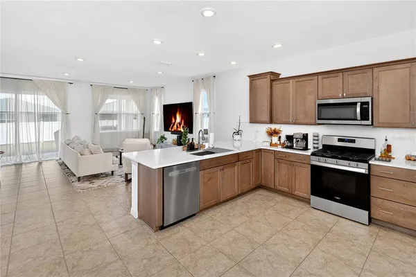 a kitchen with stainless steel appliances a stove a sink a microwave a refrigerator and cabinets