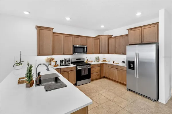 a kitchen with a sink a counter top space appliances and cabinets