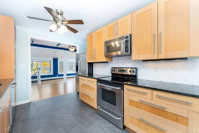 a kitchen with stainless steel appliances granite countertop a stove a sink and a microwave