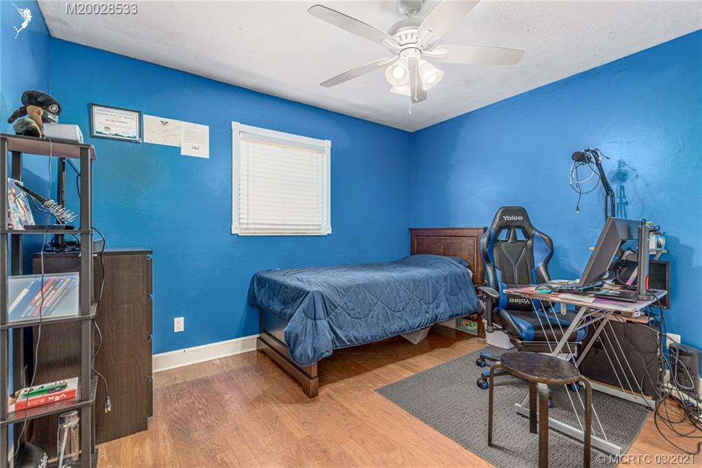 2850 Southwest Murphy Road Palm City, FL 34990 - Photo 16 of 27 a bedroom with a bed and a chandelier