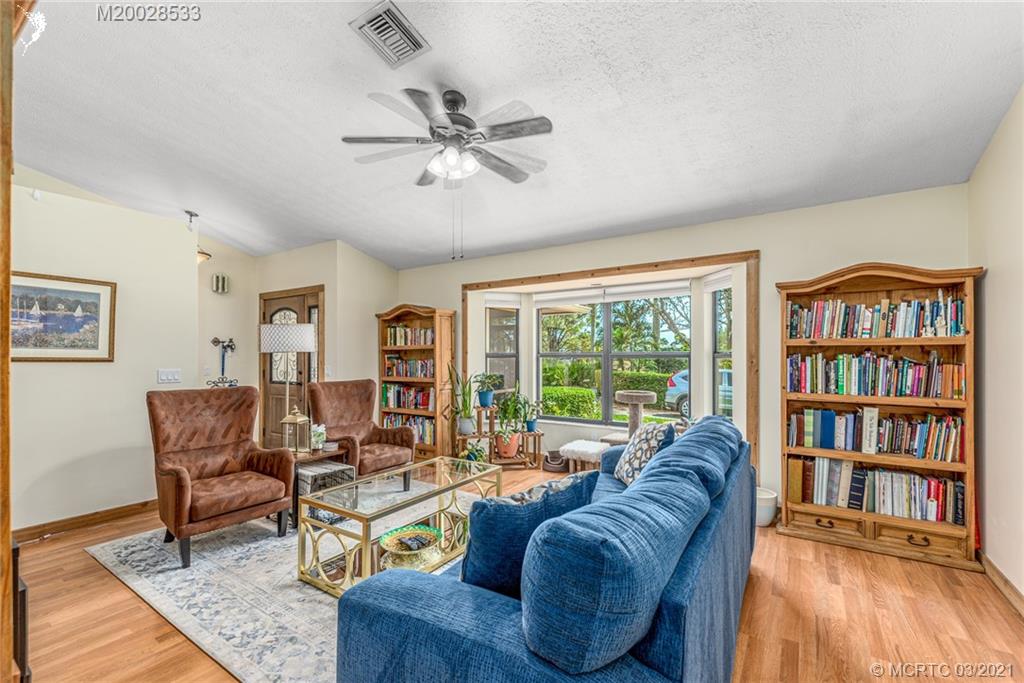 2850 Southwest Murphy Road Palm City, FL 34990 - Photo 6 of 27 a living room with furniture and a book shelf