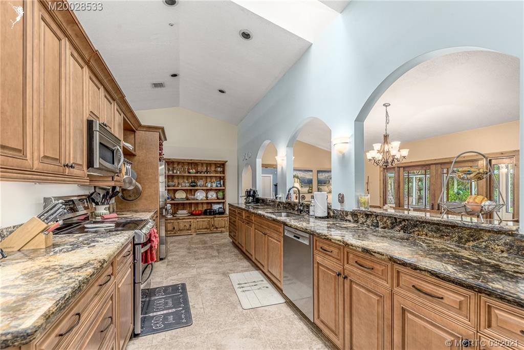 2850 Southwest Murphy Road Palm City, FL 34990 - Photo 9 of 27 a large white kitchen with stainless steel appliances granite countertop a stove and a sink