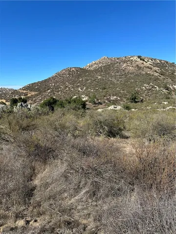 a view of a dry yard with mountains in the background