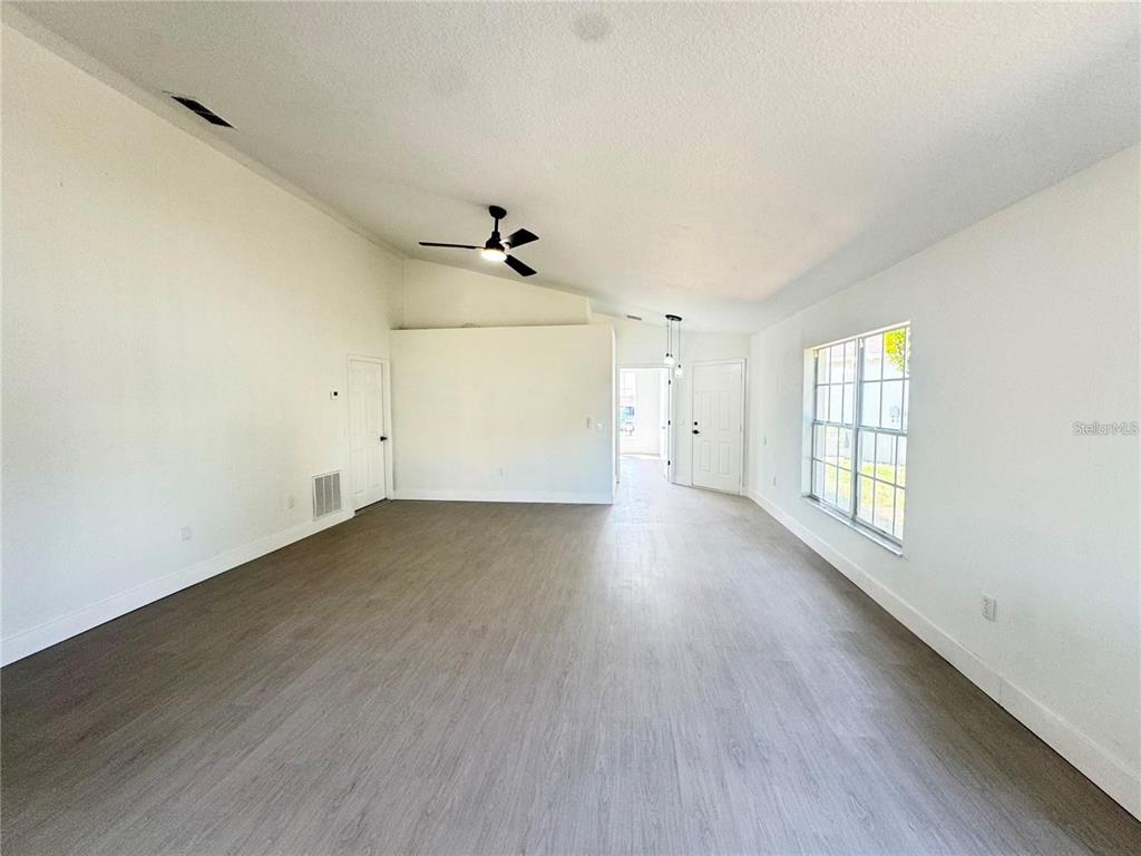 207 High Ridge Drive Davenport, FL 33837 - Photo 13 of 33 an empty room with wooden floor and windows