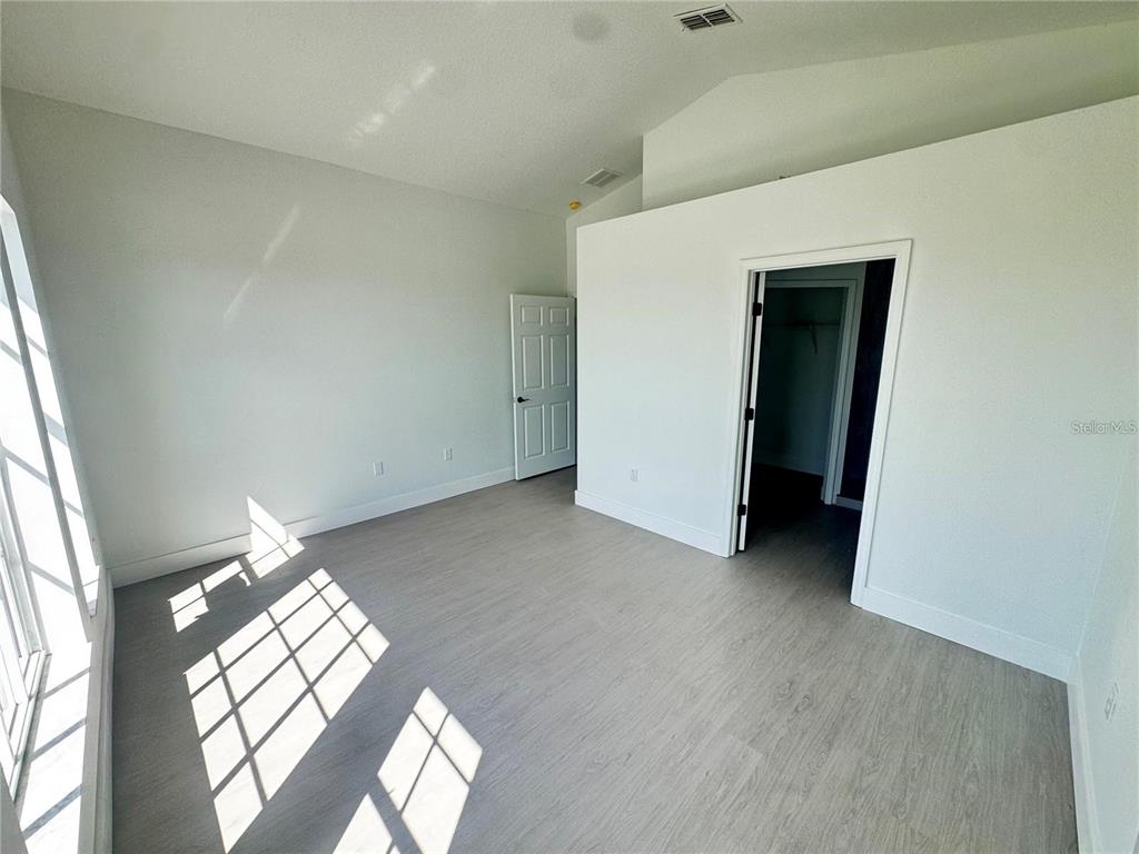 207 High Ridge Drive Davenport, FL 33837 - Photo 16 of 33 an empty room with windows and wooden floor