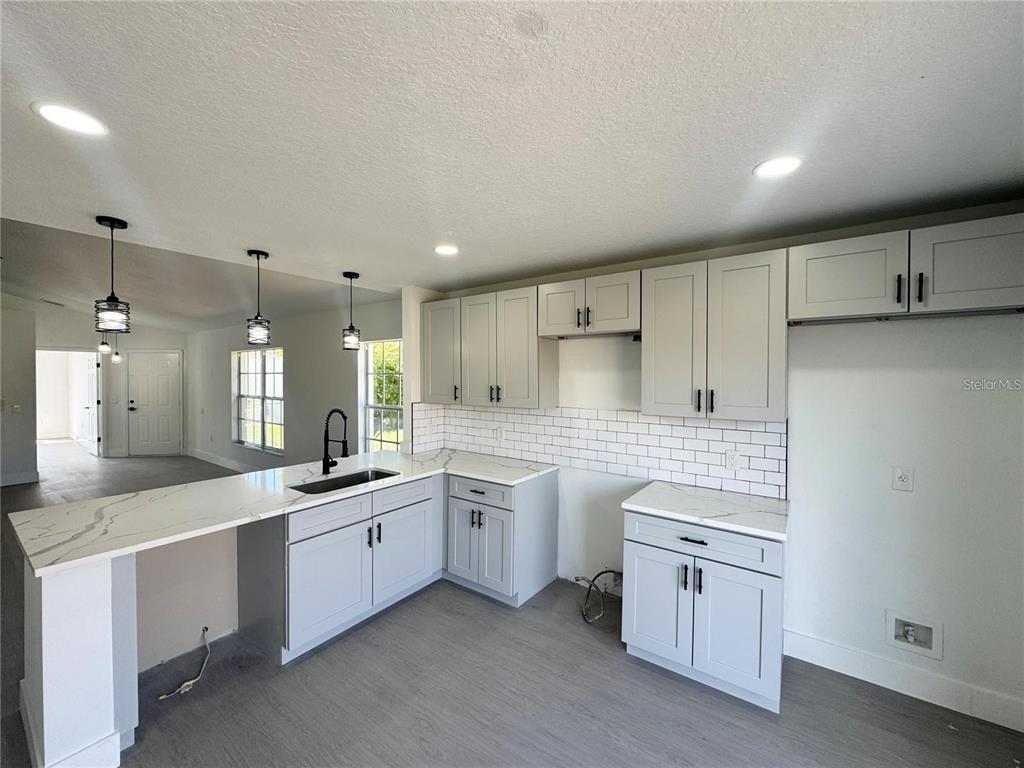 207 High Ridge Drive Davenport, FL 33837 - Photo 7 of 33 a kitchen with white cabinets appliances and a sink