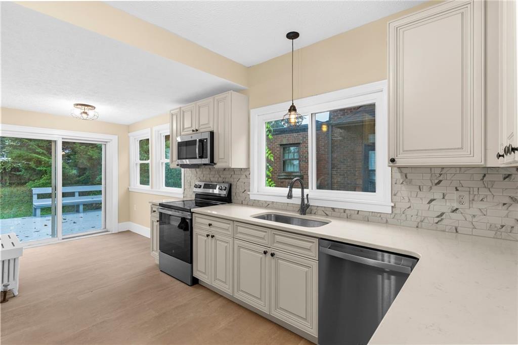 895 Alcoma Street Sharon, PA 16146 - Photo 17 of 41 a kitchen with stainless steel appliances granite countertop a sink a stove and a refrigerator