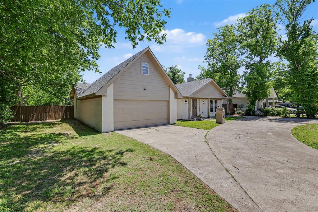 307 Dixon Street Terrell, TX 75160 - Photo 2 of 32 Exterior featuring a two-car garage, a gabled roofline, light-toned siding, a concrete driveway, and a fenced yard