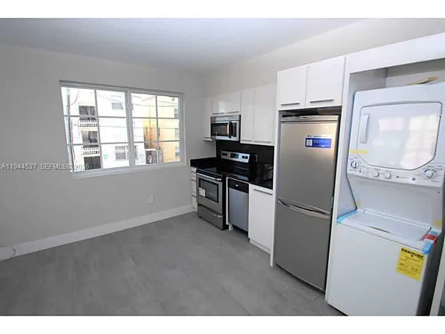 a kitchen with a refrigerator and a stove top oven