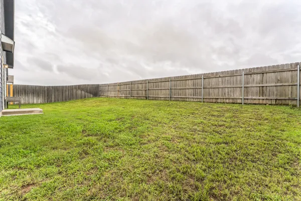 a view of a yard with wooden fence