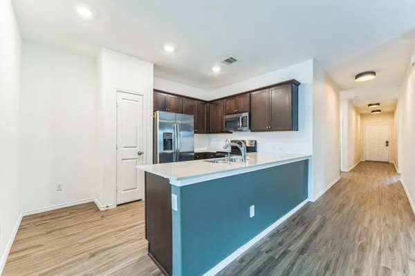 a kitchen with stainless steel appliances granite countertop a sink stove and refrigerator