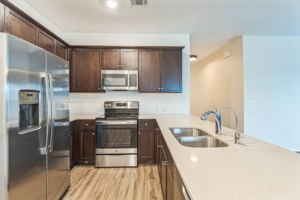 a kitchen with stainless steel appliances granite countertop a sink stove and refrigerator
