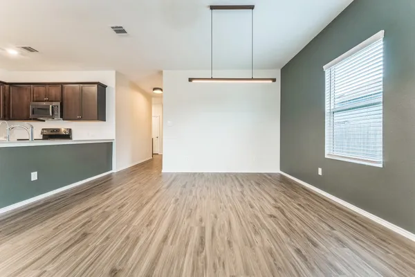 a view of kitchen with a sink wooden cabinets and stainless steel appliances