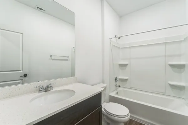 a bathroom with a granite countertop sink toilet a mirror and shower