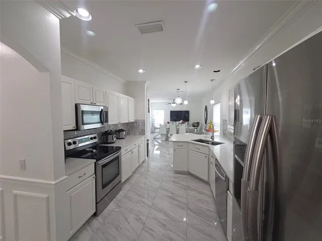 a kitchen with stainless steel appliances a refrigerator stove and sink