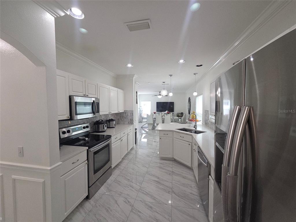 4162 Day Bridge Place Ellenton, FL 34222 - Photo 12 of 49 a kitchen with stainless steel appliances a refrigerator stove and sink