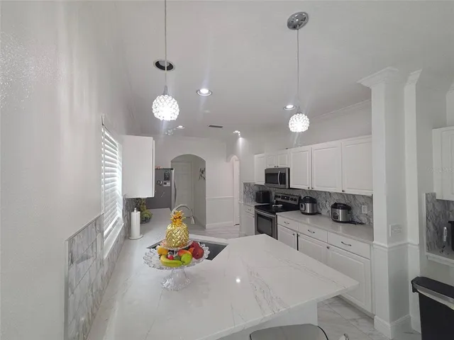 a kitchen that has a lot of cabinets a sink and appliances in it