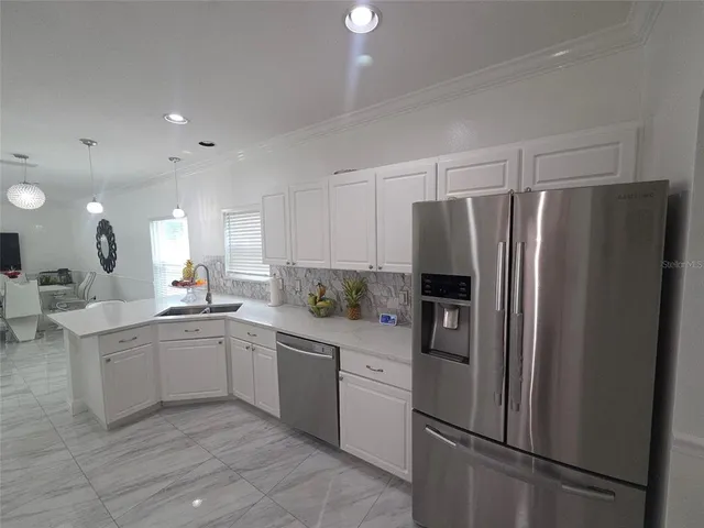 a kitchen with a refrigerator sink and cabinets