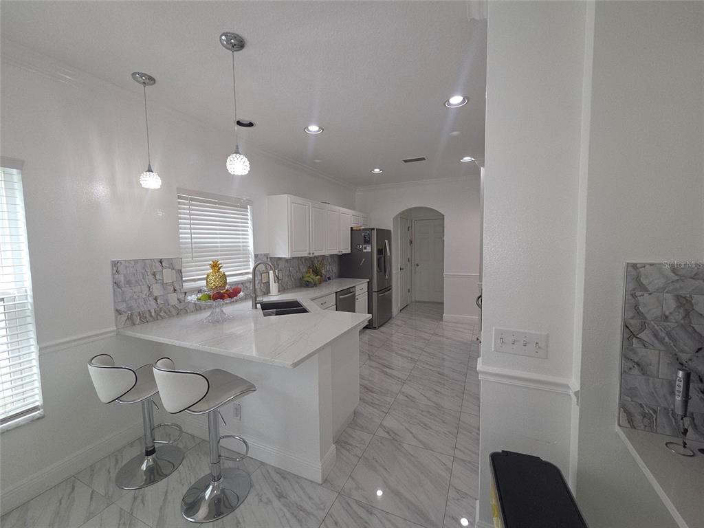 4162 Day Bridge Place Ellenton, FL 34222 - Photo 16 of 49 a kitchen with stainless steel appliances kitchen island granite countertop a sink and a refrigerator