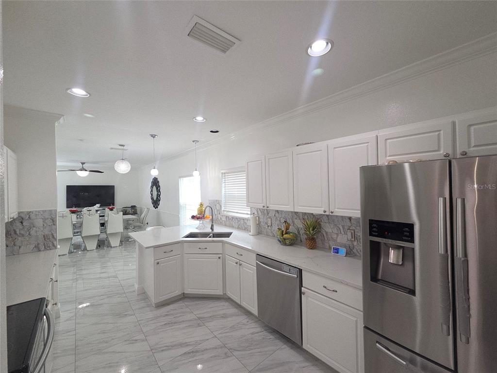 4162 Day Bridge Place Ellenton, FL 34222 - Photo 21 of 49 a kitchen with white cabinets and stainless steel appliances